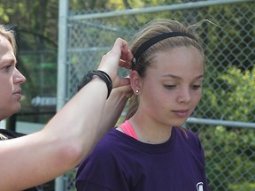 Western University researcher Alexandra Harriss adjusts a head band with micro-sensors on a soccer player participating in research on the effects of repeated hits to the head during games and practices. (Supplied photo)