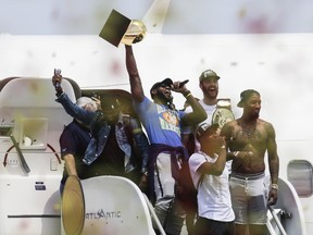 Cleveland Cavaliers' Lebron Jame holds up the NBA Championship trophy at the airport in Cleveland on June 20, 2016. (AP Photo/John Minchillo)