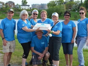 Frank Louvelle, Yvonne Thomas, Jane Skidmore-Fox, Lise Sinclair, Yvette Larabee, Pauline Robin, Lise Dumont and Findlay Barr (kneeling) are part of the Cochrane Committee for Alzheimers and celebrate the success of the  Memory Makers “Promenade at Commando Lake” with cake.