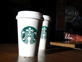 In this this Friday, Jan. 17, 2014, file photo, Starbucks cups are shown mugs in a cafe in North Andover, Mass. A federal judge in San Francisco ruled on Friday, June 17, 2016, that a lawsuit claiming the Seattle-based coffee chain under fills its lattes can move forward. (AP Photo/Elise Amendola, File)