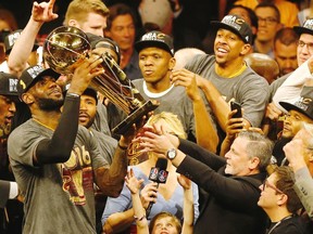 Cleveland Cavaliers forward LeBron James hoists the Larry O'Brien trophy after defeating the Golden State Warriors to win the NBA Finals on June 19, 2016 in Oakland, California.  (AFP PHOTO/Beck Diefenbach)