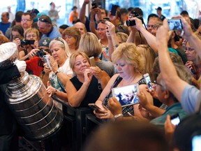 In this June 23, 2015, file photo, fans take pictures of the Stanley Cup at the MGM Grand in Las Vegas. (AP Photo/John Locher, FIle)