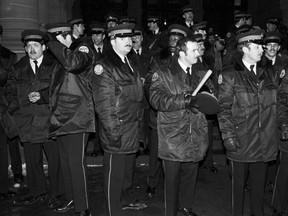 Police officers stand on the steps of the Ontario Legislature in Toronto in the early hours of Feb. 7, 1981 after gay rights demonstrators marched there in protest of the arrests on Feb. 5, 1981 of 253 men in four city steam baths. (THE CANADIAN PRESS/UPC/Gary Hershorn)