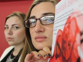 Samantha Reed/The Intelligencer 
Slut Walk organizer Caitlin Sextun holds a promotional poster for this year's Slut Walk, while fellow organizer Elissa Robertson stands in the background. This year's walk kicks off on Jun. 25 and raises awareness about victim blaming.