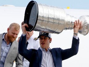 Pittsburgh Penguins' Sidney Crosby, right, gets off the jet from California with the Stanley Cup. (AP Photo/Keith Srakocic)