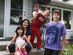 Angela Mao and her kids, Ciella (left), 6, and Dominic (third from left), 9, pose for a photo with neighbours Victor (second from right), 8, and Ethan, 12, outside her bungalow in Forrest Heights in Edmonton on Tuesday, June 21, 2016. Mao and her partner were able to afford the home seven years ago by renting out the basement suite. IAN KUCERAK / Postmedia Network