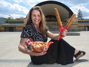 Billie Campbell with a bowl of Canadian poutine and two corn dogs -- two of the traditional foods she will be serving during this weekend's International Food Festival in Victoria Park. (MORRIS LAMONT, The London Free Press)