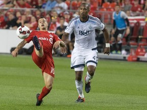 Toronto FC's Sebastian Giovinco (left) controls the ball as Vancouver Whitecaps' Kendall Watson defends during the first leg of the Canadian Championship final at BMO Field on Tuesday night. (Chris Young/The Canadian Press)