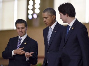 President Barack Obama, center, walks with Mexico's President Enrique Pena Nieto, left, Canada's Prime Minister Justin Trudeau, right, at the Asia-Pacific Economic Cooperation summit in Manila, Philippines, on Nov. 19, 2015. senior Canadian official says clean energy and climate policy will be a dominant theme when the leaders of Canada, the United States and Mexico convene June 29 in Ottawa. (Susan Walsh/The Canadian Press/AP)
