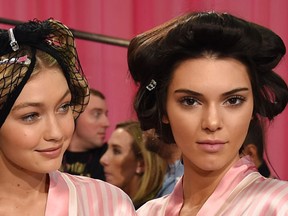 FILE - Gigi Hadid (L) and Kendall Jenner are seen backstage before the 2015 Victoria's Secret Fashion Show at Lexington Avenue Armory on November 10, 2015 in New York City.  (Dimitrios Kambouris/Getty Images for Victoria's Secret/AFP)