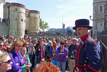 This May 21, 2015 photo shows tourists gathering at The Tower of London for a guided tour by a Yeoman Warder, of Beefeater, in London. There’s plenty of sights to see for families on vacation in London, like the Harry Potter studio tour, Big Ben and the London Eye.  (AP Photo/Ross D. Franklin)