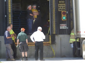 Emergency workers examine the area where a worker trapped between a truck and a forklift at Sofina Foods on Wednesday in London. (MORRIS LAMONT, The London Free Press)