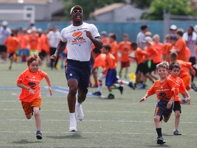 Denver Broncos linebacker Von Miller runs with participants, as the Super Bowl 50 MVP hosts a football camp for kids on a high school field, Wednesday, June 22, 2016, in Englewood, Colo. Miller is still mired in a contract stalemate with the Broncos. (AP Photo/David Zalubowski)