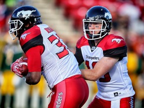 Calgary Stampeders quarterback Bo Levi Mitchell hands the ball off to running back Jerome Messam during a pre-season game against the Edmonton Eskimos in Calgary Saturday, June 11, 2016. (Al Charest/Postmedia Network)