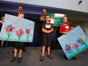 Andrew Otway, President and CEO of the Royal Alexandra Hospital Foundation and Mike House , President and CEO of the Stollery Children's Hospital Foundation wait to receive thank you cards from six year old triplets Liam, David and Ryan Ennis during a press conference at the University of Alberta on Wednesday, June 22, 2016. Greg Southam/Postmedia Network