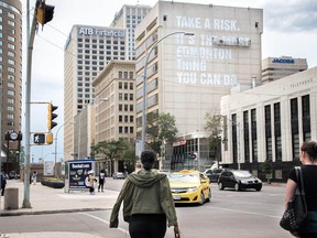 Final touches are put on the Wall of Encouragement in downtown Edmonton, Tuesday, June 21, 2016.  The mural is on Melcor's 100 St. Place building. Created and installed by local designer Clay Lowe, it reads, "Take a risk. It's the most Edmonton thing you can do."  MARKETWIRED PHOTO/Melcor Developments Ltd.