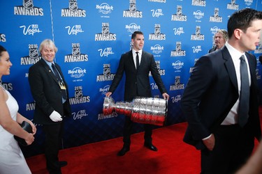 Pittsburgh Penguins' Pascal Dupuis holds up the Stanley Cup on the red carpet before the NHL Awards show, Wednesday, June 22, 2016, in Las Vegas. (AP Photo/John Locher)