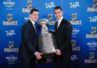 Pittsburgh Penguins' Sidney Crosby, left, and Pascal Dupuis hold up the Stanley Cup on the red carpet before the NHL Awards show, Wednesday, June 22, 2016, in Las Vegas. (AP Photo/John Locher)
