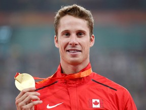 Corunna's Derek Drouin holds his gold medal on the podium during the ceremony for the men’s high jump at the World Athletics Championships in Beijing on Aug. 30, 2015. Drouin and fellow 2012 Canadian Olympian Chelsea Aubry will be posing for pictures and signing autographs at Sarnia Fine Cars this Saturday as part of BMW Canada Group's Drive For Team Canada event. (AP Photo/Ng Han Guan)