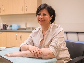 Maryam Zolfi, who had a successful arm transplant, poses for a picture showing her right hand resting on top of her transplanted arm, at Toronto Western Hospital, in Toronto, Monday, June 20, 2016. (THE CANADIAN PRESS/Mark Blinch)