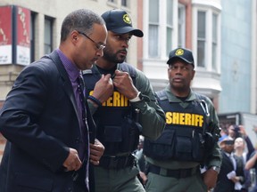 Officer Caesar Goodson, left, one of six Baltimore city police officers charged in connection to the death of Freddie Gray, arrives at a courthouse before receiving a verdict in his trial in Baltimore, Thursday, June 23, 2016. (AP Photo/Patrick Semansky)
