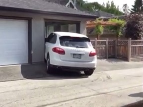 A white Porsche Cayenne SUV is seen struggling to get into a parking spot. (YouTube screenshot)