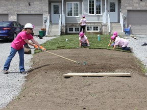 DRHBA President Heidi Stephenson, foreground left, works on the front yard of a Centretowne Home at the Women in Power Habitat for Humanity Durham Build last week.