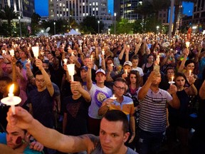 In this Monday, June 13, 2016, file photo, crowd members hold up candles during a vigil downtown for the victims of a mass shooting at the Pulse nightclub in Orlando, Fla. Some small business owners already working to make their companies more welcoming to LGBT employees say the massacre at gay dance club Pulse gives them an impetus to make more changes. (AP Photo/David Goldman, File)