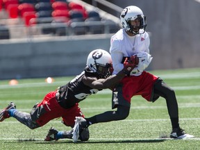 Ottawa Redblacks wide receiver Chris Williams makes a catch as defensive back Jerrell Gavins makes the tackle during practice at TD Place in Ottawa on June 21, 2016. (Errol McGihon/Postmedia)