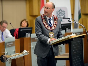 Mayor Matt Brown hands out community appreciation awards at the start of a city council meeting at London City Hall on Thursday. It was the first meeting Brown has been back as mayor after taking a leave related to his admitted affair with deputy-mayor Maureen Cassidy last week. (MORRIS LAMONT, The London Free Press)