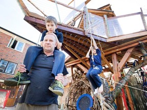 John Alpeza and his sons Mateas, 8, left, and Kristin, 10, right, in their back yard with their Toronto home tree house which the city says needs to come down, Tuesday April 19, 2016. (Peter J. Thompson/Postmedia Network)