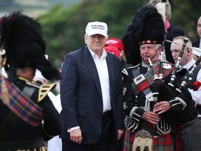 Presumptive Republican presidential nominee Donald Trump poses with a bagpiper as he arrives at his revamped Trump Turnberry golf course in Turnberry, Scotland, Friday, June 24, 2016. Trump saluted the United Kingdom's vote to leave the European Union, saying "they took back their country, it's a great thing." Trump arrived at his Turnberry golf course in Scotland a day after the so-called Brexit vote. (Andrew Milligan/PA via AP)