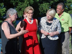Susanna Suchak, garden coordinator at Salt Creek Market and consultant to the Elgin county branch of the Canadian Mental Health Association, talks to Ontario Premier Kathleen Wynne, Deputy Premier Deb Matthews and Steve Peters, manager of Salt Creek Farm Market, at the ceremonial opening of the market Thursday.