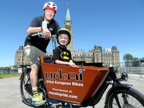 Andrew Sedmihradsky, his son Max and the bicycle that will take them to Hamilton. Julie Oliver/Postmedia