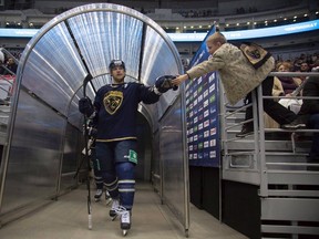 In this photo taken on Monday, Jan. 12, 2015, a fan greets Sochi defender Clay Wilson during a KHL game against Atlant at the Bolshoy Ice Dome in Sochi, Russia. (THE CANADIAN PRESS/AP/Dmitry Lovetsky)