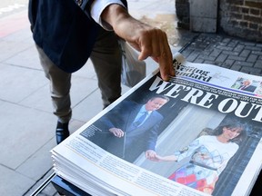 A man takes a copy of the London Evening Standard with the front page reporting the resignation of British Prime Minister David Cameron and the vote to leave the EU in a referendum. (AFP PHOTO)