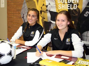Morgan Melnek, left, and Kianna Houben take part in a signing ceremony to join the Cambrian Golden Shield women's soccer team for 2016-17 at the college on Friday. Ben Leeson/The Sudbury Star/Postmedia Network