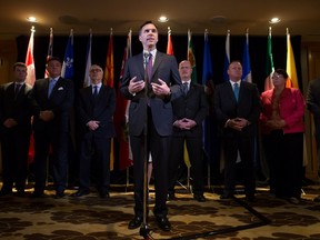 Federal Finance Minister Bill Morneau, centre, is flanked by his provincial and territorial counterparts as he speaks during a news conference after reaching a deal to expand the Canada Pension Plan, in Vancouver, B.C., on Monday June 20, 2016. THE CANADIAN PRESS/Darryl Dyck