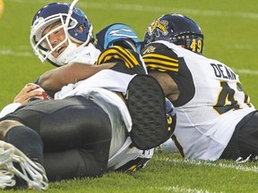 Argonauts quarterback Ricky Ray is sacked by linebacker Larry Dean of the Tiger-Cats during Thursday’s 42-20 Hamilton victory at BMO Field. (The Canadian Press)