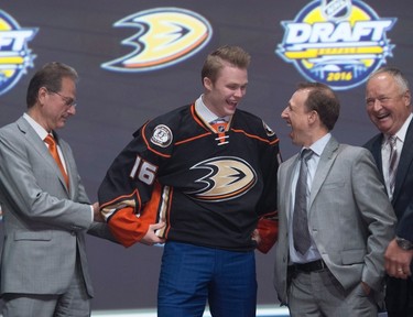 TWENTY FOURTH PICK: MAX JONES, ANAHEIM DUCKS Max Jones smiles as he puts on his sweater as he stands on stage with members of the Anaheim Ducks management team during the NHL Draft in Buffalo on June 24, 2016. (Nathan Denette/Canadian Press)