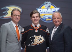 Matthew Tkachuk, sixth overall pick, stands on stage with members of the  Calgary Flames management team at the NHL draft in Buffalo, N.Y. on Friday  June 24, 2016. THE CANADIAN PRESS/Nathan Denette