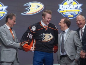 Max Jones smiles as he puts on his sweater as he stands on stage with members of the Anaheim Ducks management team at the NHL draft in Buffalo, N.Y. on Friday June 24, 2016. THE CANADIAN PRESS/Nathan Denette
