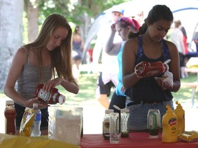 Mackenzie Meyers and Sofia Mufti dress their hot dogs at the United Way’s 75th Anniversary Community Caring Celebration in Lake Ontario Park on Saturday, June 25, 2016. Steph Crosier, Kingston Whig-Standard, Postmedia Network