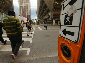 Pedestrians cross the street at Bay and Bloor Sts.  (Sun file photo)