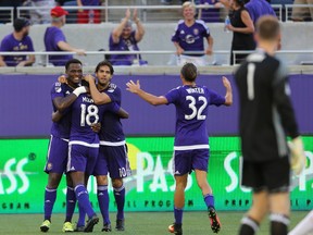 Orlando City forward Cyle Larin (left) celebrates his goal with teammates during last night’s game against Toronto FC. (AP)