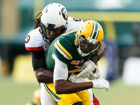 Edmonton's Adarius Bowman (4) is tackled by Ottawa's Aston Whiteside (91) during a CFL game between the Edmonton Eskimos and the Ottawa Redblacks at the Brick Field at Commonwealth Stadium in Edmonton on June 25, 2016.