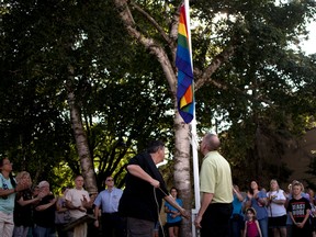Kelly Walker, a member of the Oxford County Pride Committee, raises the pride flag in Ingersoll for a second time after the flag was torn down and thrown in the trash on Tuesday. (BRUCE CHESSELL/Sentinel-Review)