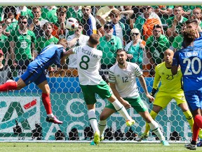 France's Antoine Griezmann, left, scores his side’s first goal during the Euro 2016 round of 16 soccer match between France and Ireland, at the Grand Stade in Decines-­Charpieu, near Lyon, France, Sunday, June 26, 2016. (AP Photo/Thanassis Stavrakis)
