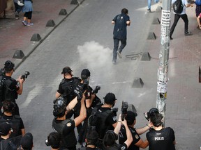 Turkish police officers fire tear gas and rubber bullets to disperse demonstrators who gathered for a gay pride rally despite a government ban, off Istiklal Avenue, central Istanbul's main shopping road, Sunday, June 19, 2016. Istanbul's governor had banned gay, lesbian and transgender individuals from holding two annual parades this year citing security concerns. (AP Photo/ Emrah Gurel)