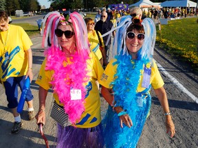 Belleville friends Jenny DeCoste, centre, and Camilla Summers walk in the survivors' lap of the Relay for Life in Belleville Friday. It raised more than $109,000 for the Canadian Cancer Society, bringing this season's regional relay total to $450,000.